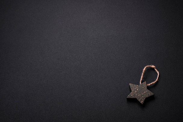 Piękne teksturowane ciemnobetonowe tło z zabawką w kształcie gwiazdy choinki. Przygotowania do obchodów nowego roku - Zdjęcie, obraz