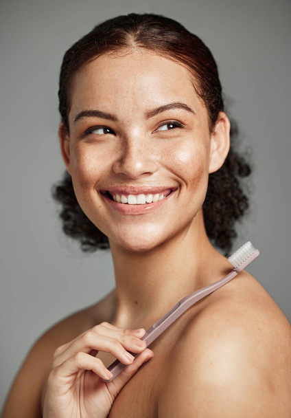 Toothbrush, woman brushing teeth and dental wellness with hygiene, cleaning and teeth whitening. Face of a happy female with a smile for oral health, healthy mouth and self care on studio background. - Foto, afbeelding