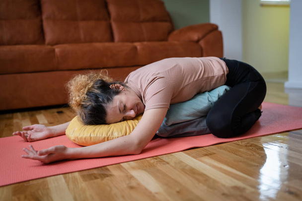 One adult caucasian woman practice restorative yoga at home - Foto, imagen