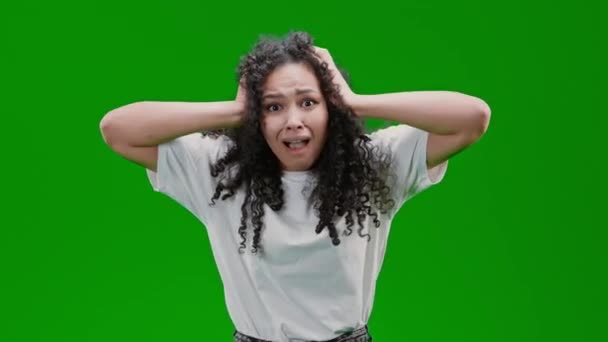 смущенная и испуганная женщина с кудрявыми длинными волосами одета в белую футболку Изолированный на зеленом экране - Кадры, видео