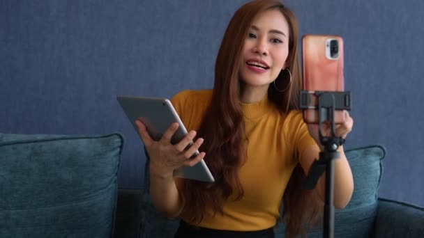 アジアの女性ライフコーチのビデオでは、学生とビジネスの成功を提案しています。ソーシャルメディアでの若い起業家ストリーミング,自由とアクティブなライフスタイルの概念,ライブビデオを介して販売を通信. - 映像、動画