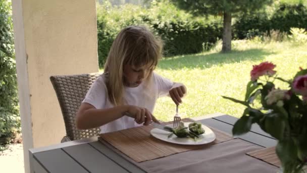 Girl of 7 years old has broccoli as a lunch. High quality 4k footage - Materiał filmowy, wideo