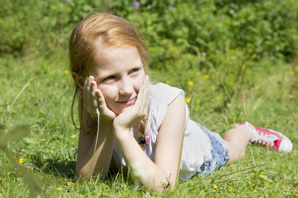 Hermosa chica sentada en el prado
 - Foto, imagen