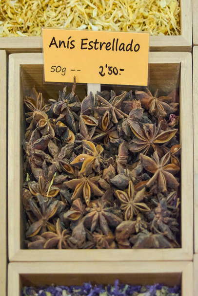 Belediye pazarındaki ahşap bir kutunun içindeki yıldız anason tohumunun fiyatı 50 gram başına avro.. - Fotoğraf, Görsel
