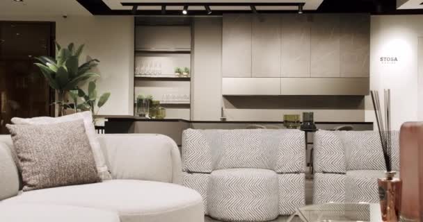 Modern contemporary Minimalist living room with white and beige furniture and white kitchen room. Luxury Modern House Interior With Corner Sofa, Chairs and Bookshelf. Fashionable furniture. - Filmmaterial, Video
