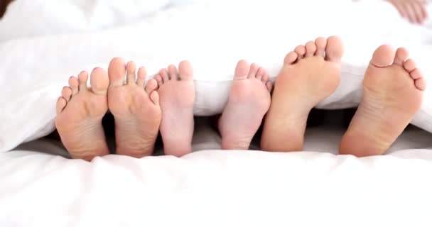 ベッドの両親と子供の家族の足。家族の快適な睡眠ベッドルームまたはホテル - 映像、動画