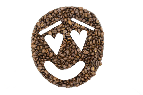 Coffee beans arranged on a white background to look like an emoji - Fotó, kép