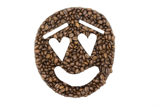Coffee beans arranged on a white background to look like an emoji - Photo, image
