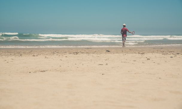 Hombre activo con camisa roja en la playa jugando con frisbee. Suma
 - Foto, Imagen