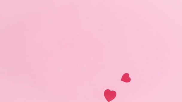 4k На розовом фоне пролетает группа красных бумажных сердец, синонимов любви. Поздравительная открытка. День Святого Валентина. Шаблон для текста или дизайна. Принято. Плоский лежал. Остановить анимацию. - Кадры, видео