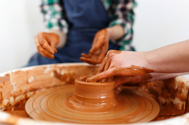 Cropped Image of Unrecognizables Females Ceramics Maker working with Pottery Wheel in Cozy Workshop Makes a Future Vase or Mug,Creative People Handcraft Pottery Class - Foto, afbeelding