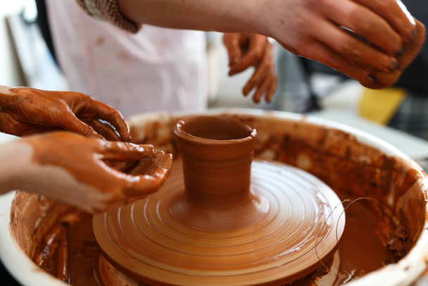 Cropped Image of Unrecognizable Female Ceramics Maker working with Pottery Wheel in Cozy Workshop Makes a Future Vase or Mug,Creative People Handcraft Pottery Class - Foto, afbeelding