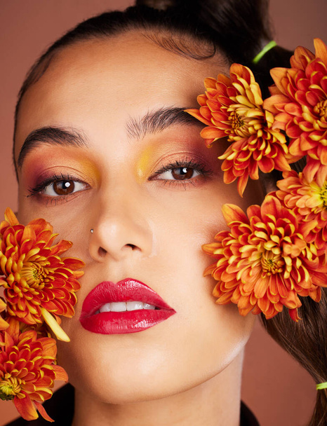 Makeup, beauty or woman in studio with flowers for art fashion and natural facial cosmetics for self care. Face portrait, orange plants or girl model with red lipstick, eyeshadow and glowing skin. - Foto, Bild