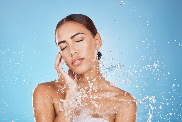 Woman skincare, hand or water splash face on blue background studio in healthcare wellness, Brazil hygiene maintenance or bathroom grooming. Beauty model, shower or wet water drop for facial cleaning. - Foto, Imagem