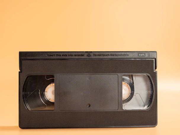 Old VHS cassettes on an orange background. Retro video cassettes. Close-up. - Zdjęcie, obraz