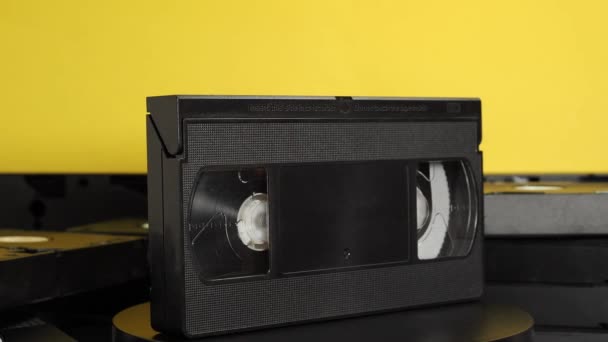Вращаем старые кассеты VHS на жёлтом фоне. видеокассеты ретро. макро. - Кадры, видео