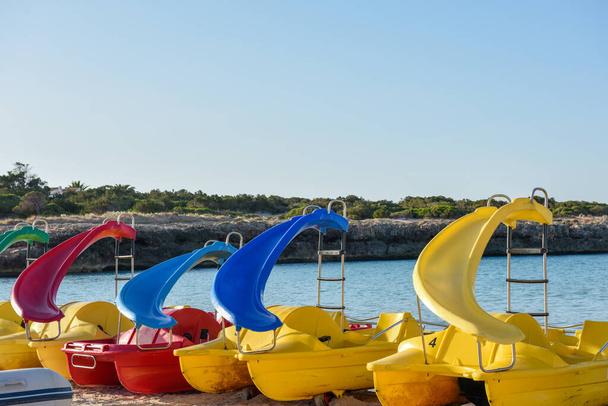 Paddle boats or pedalo lined up by the sea at the beach - Foto, imagen