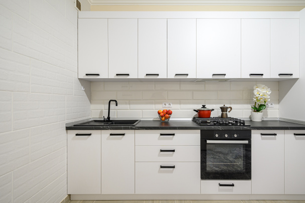 Moderno escaparate interior de cocina moderna blanca como la nieve con muebles minimalistas, vista frontal - Foto, imagen