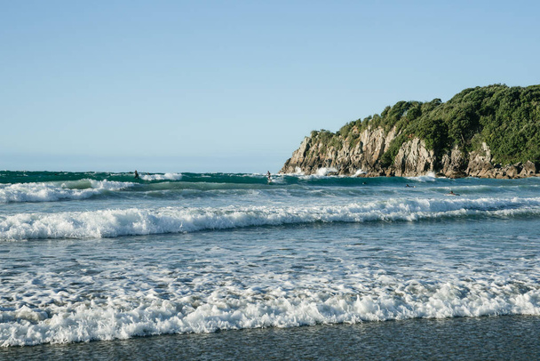 Surf waves roll in onto Main Beach, Mount Maunganui by Moturiki Island on summer day. - Foto, immagini