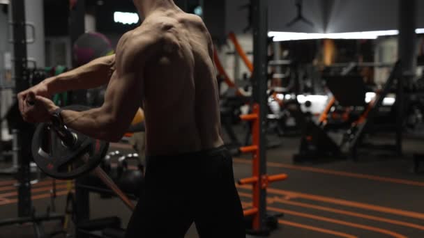back view of athletic man in sport gym do landmine exercise. sport athletic man with barbell landmine in gym. athletic man with sport barbell equipment in gym. - Záběry, video