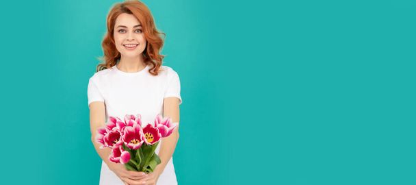 glad woman with tulip flower bouquet on blue background. Woman isolated face portrait, banner with mock up copyspace - Foto, immagini
