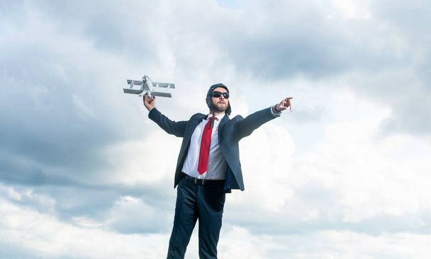 successful businessman in suit and pilot hat launch plane toy on sky background. - Zdjęcie, obraz