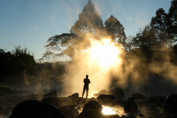January 8, 2023; Hot springs and fog in Thailand with morning sunlight. Morning atmosphere at Chae Son National Park, silhouette of tourists enjoying the beauty of natural hot spring in Lampang, Thail - Foto, Imagen
