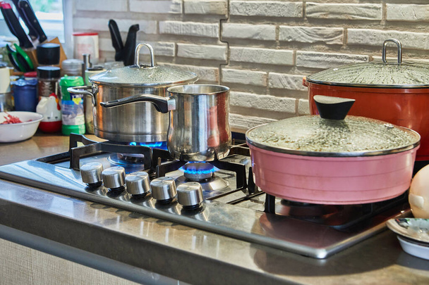 Cooking food in frying pan and pot on gas stove in the kitchen. Home cooking concept. - Photo, Image