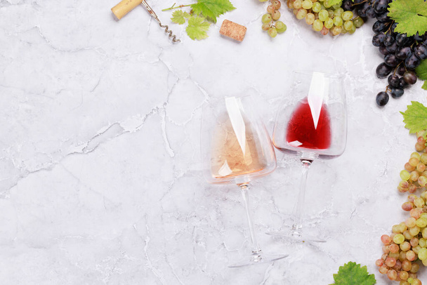 Blanco, rosa y copas de vino tinto y uva. Puesta plana - Foto, imagen