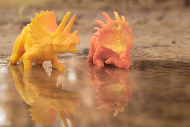 湖をうろついている恐竜のおもちゃは - 写真・画像
