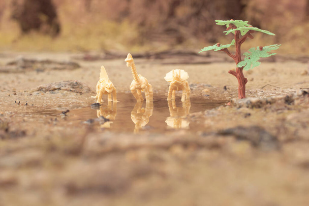 湖をうろついている恐竜のおもちゃは - 写真・画像