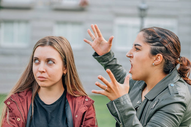two female friends arguing in the street outdoors - Foto, Imagen