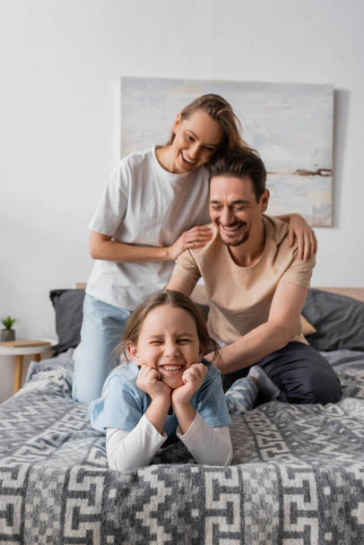 cheerful woman hugging happy husband tickling smiling daughter at home   - Photo, image