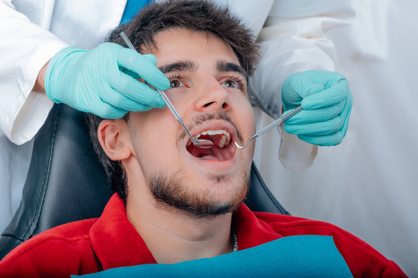 pacient u zubaře, ruce s nářadím zubaře - Fotografie, Obrázek