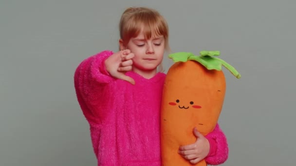 Dislike. Upset young preteen child girl kid showing thumbs down sign gesture, expressing discontent, disapproval, dissatisfied bad work indoors. Displeased toddler children on gray studio background - Imágenes, Vídeo
