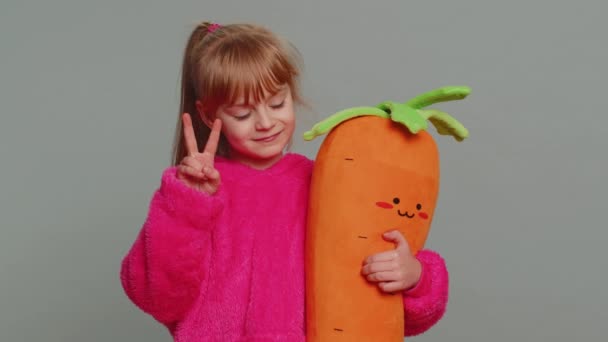 Young preteen child girl kid showing victory sign, hoping for success and win, doing peace gesture, smiling with kind optimistic expression. Little toddler children on studio gray background - Filmagem, Vídeo