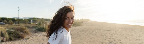 İspanya 'nın kumlu sahillerinde gülümseyen beyaz tişörtlü neşeli genç kadın, afiş.  - Fotoğraf, Görsel