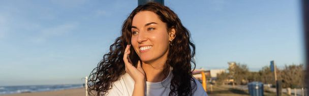 vidám fiatal nő beszél okostelefon tengerparton Barcelonában, banner  - Fotó, kép