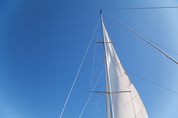 Mast and sail of yacht on blue sky background - Foto, Imagen
