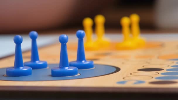 People play Ludo or Pachisi board game on beautiful wooden play board. Ludo is a strategy board game for two to four players. 4K resolution family board game video. - Filmagem, Vídeo