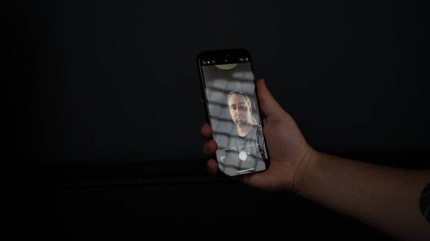 hand holding smartphone with black background - Foto, Imagem