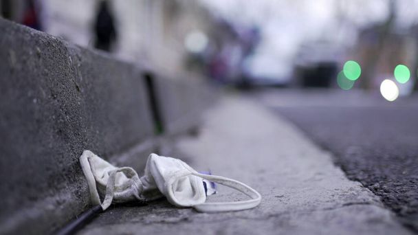 Face mask waste on ground pollution. Disposable dirty mask on sidewalk - Valokuva, kuva