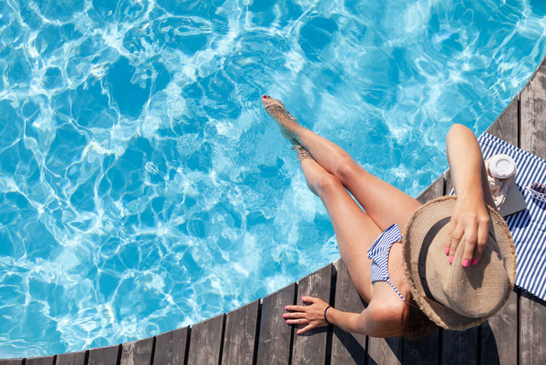 Γυναίκα σε ξύλινο κατάστρωμα κοντά στην πισίνα. Καλοκαιρινές διακοπές - Φωτογραφία, εικόνα