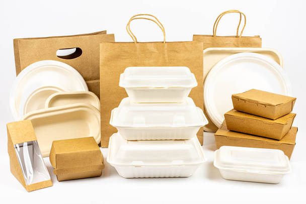 生分解性およびリサイクル可能な食品包装のグループショット白い背景、紙プレート、カップ、容器、バッグ、ロゴなし - 写真・画像
