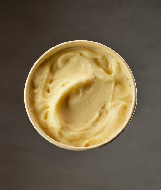 open homemade vanilla ice cream container on dark grey background - Photo, image