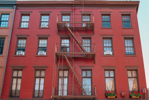 Фасад красного кирпича Нью-Йоркский жилой дом с пожарной лестницей на фронте в Гринвич Виллидж, Нью-Йорк, США. - Фото, изображение