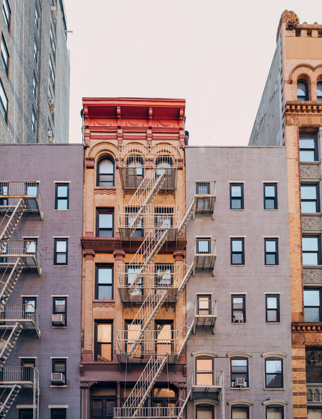 Фасад типичных нью-йоркских многоквартирных домов с пожарной лестницей на фасаде в Нохо, Нью-Йорк, США. - Фото, изображение