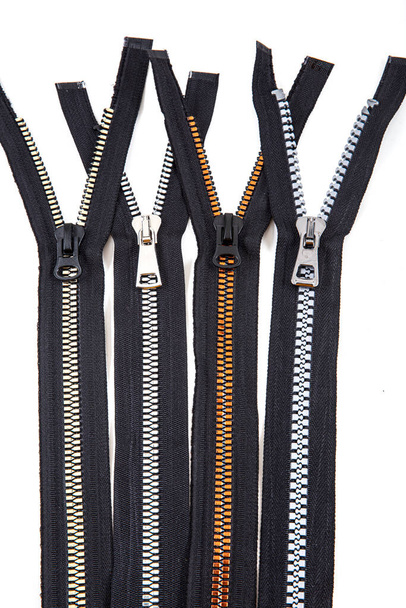 Jacket Winter Coat Black Tape Heavy Duty Zippers Large Molded Plastic Zippers. Close-up of zipper slider on a white surface. Sewing production, materials and accessories. - Foto, Imagem