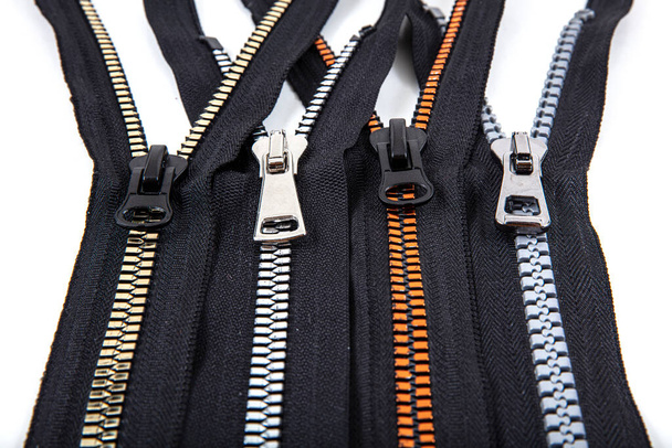 Jacket Winter Coat Black Tape Heavy Duty Zippers Large Molded Plastic Zippers. Close-up of zipper slider on a white surface. Sewing production, materials and accessories. - Fotografie, Obrázek