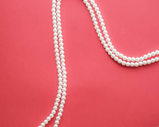 Pearl jewellery necklace on coral background. - Zdjęcie, obraz